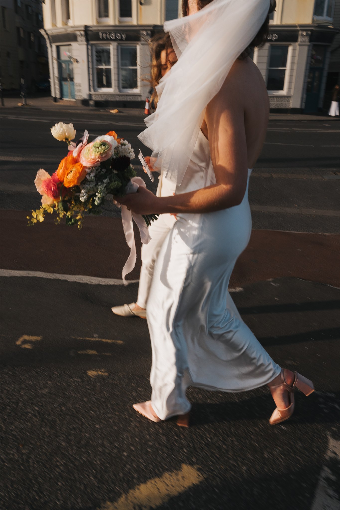 Motion blur of bride and modern bouquet on Brighton streets