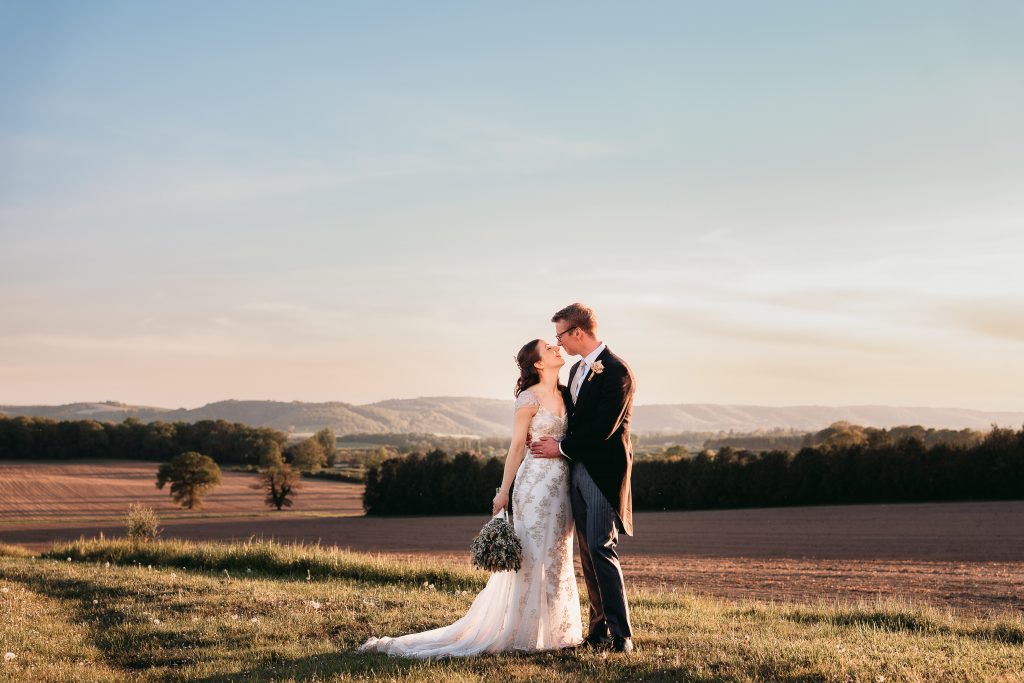 Fitzleroi Barn West Sussex Wedding Couple with South Downs view to background 