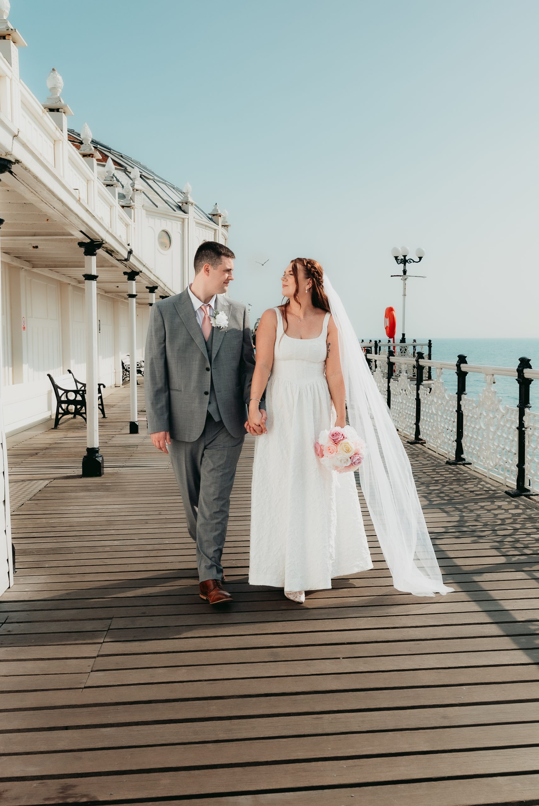 A newly married couple walking along Brighton Palace Pier after their Town Hall wedding