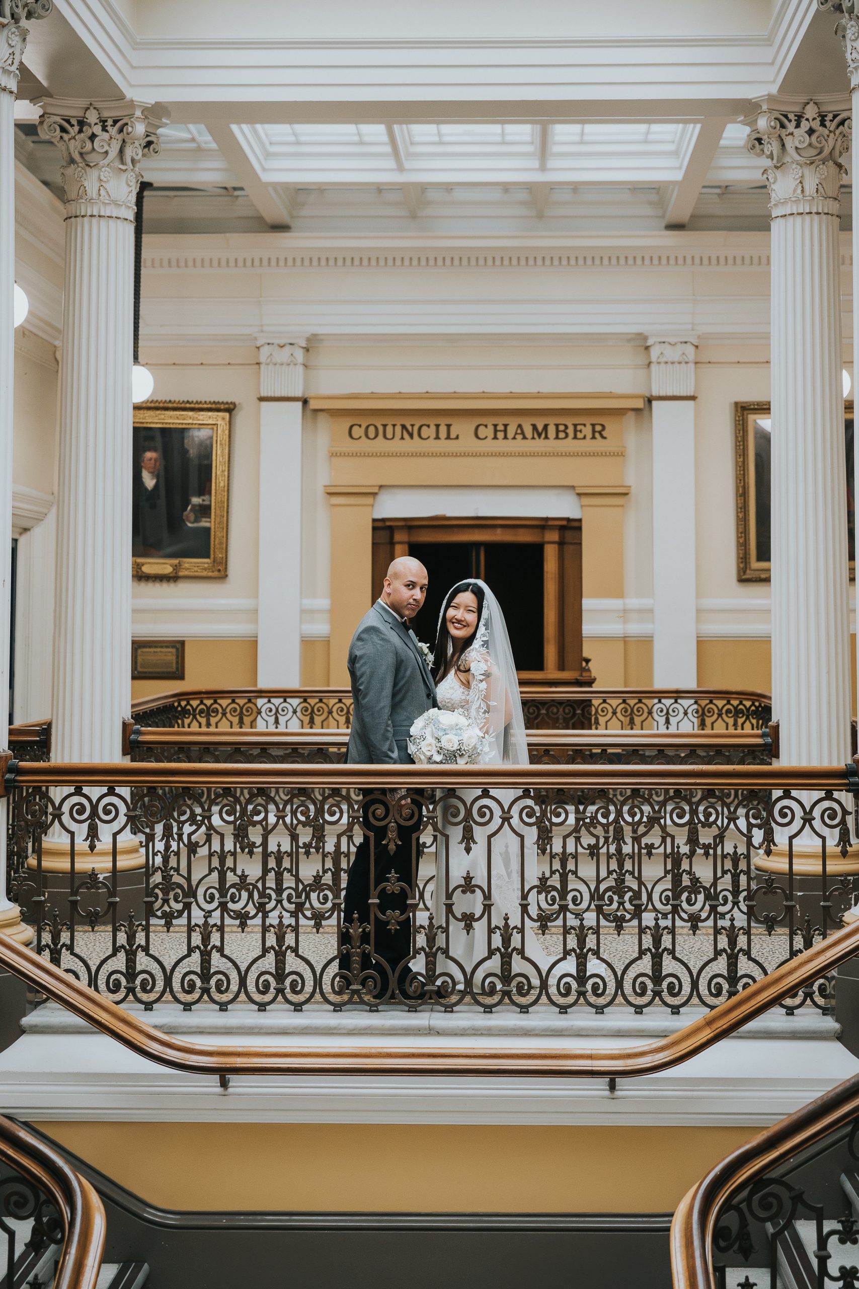Bride and groom standing on the Council Chamber balcony at Brighton Town Hall