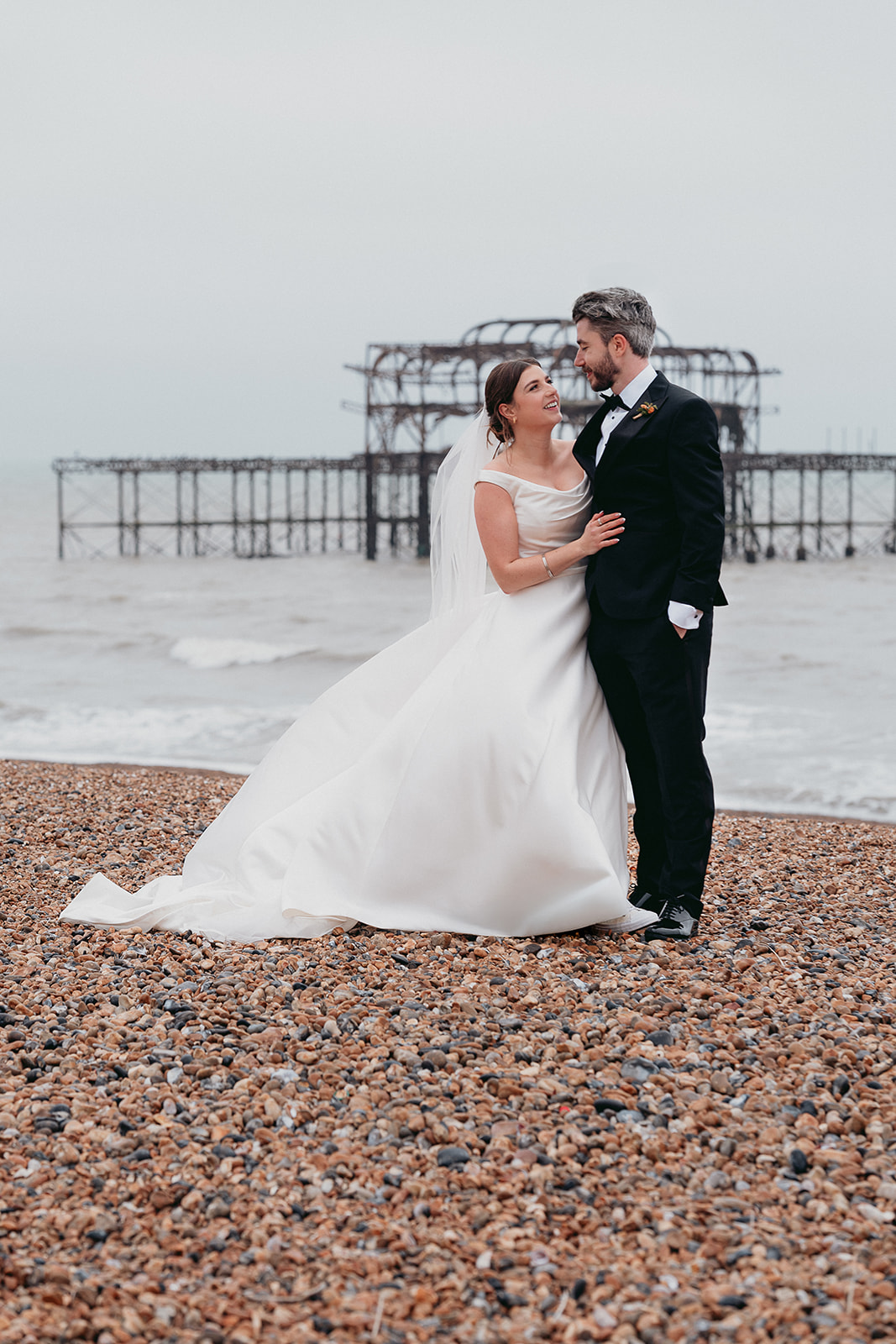 Newlyweds on Brighton Beach in the rain after their Brighton Town Hall wedding