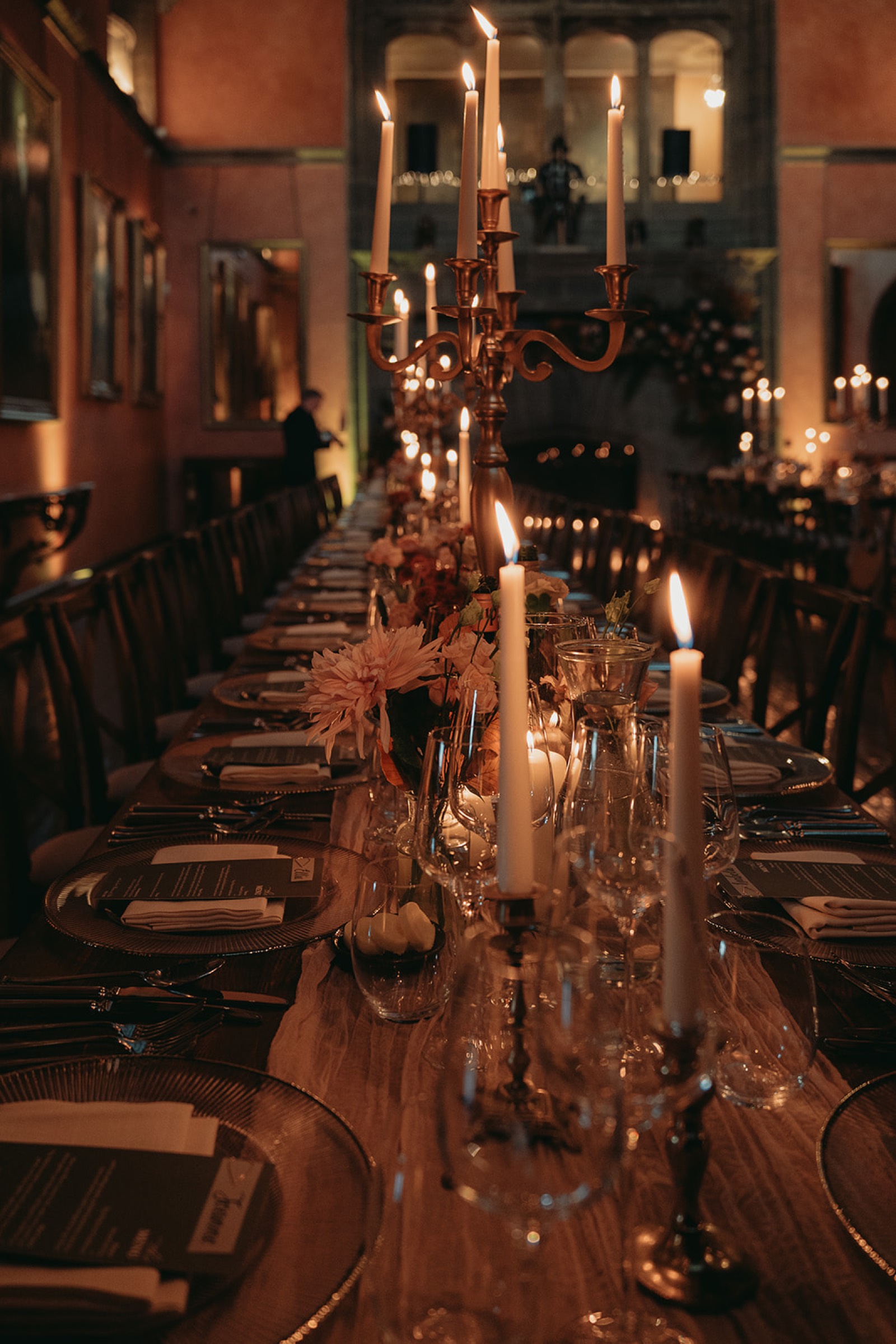 Candlelit wedding table set with glassware and seasonal flowers
