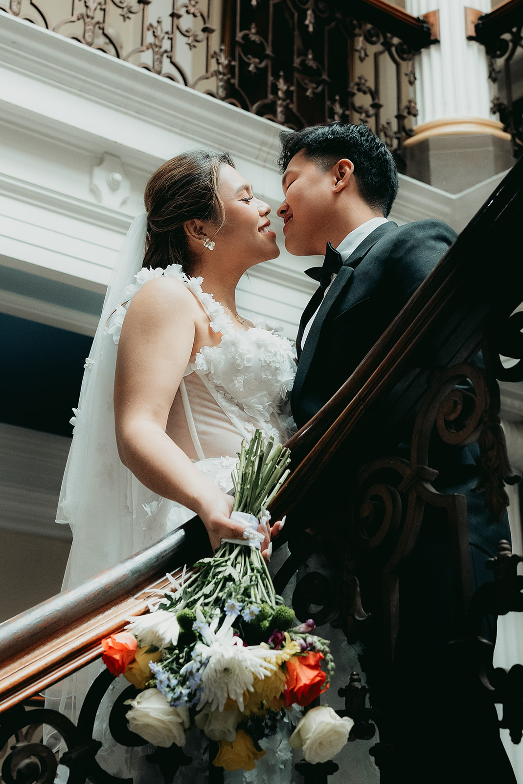 A newly married couple sharing a quiet portrait on Brighton Town Hall’s staircase