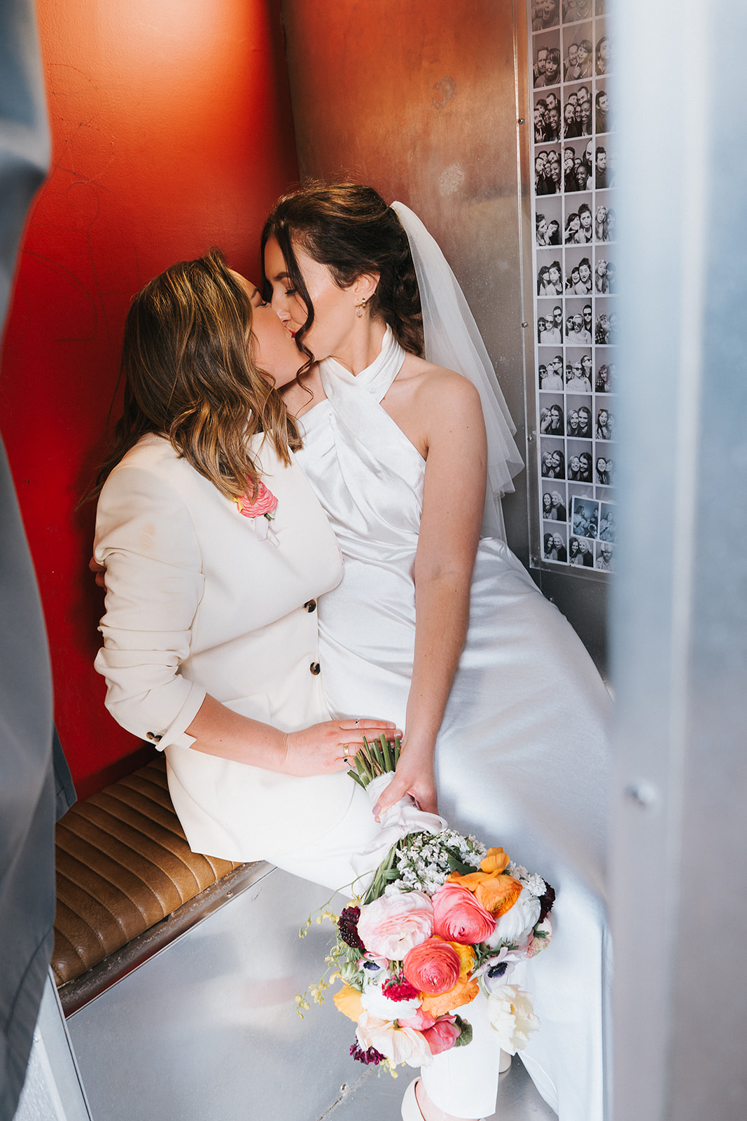 Two brides kissing in the photobooth on Brighton Palace Pier