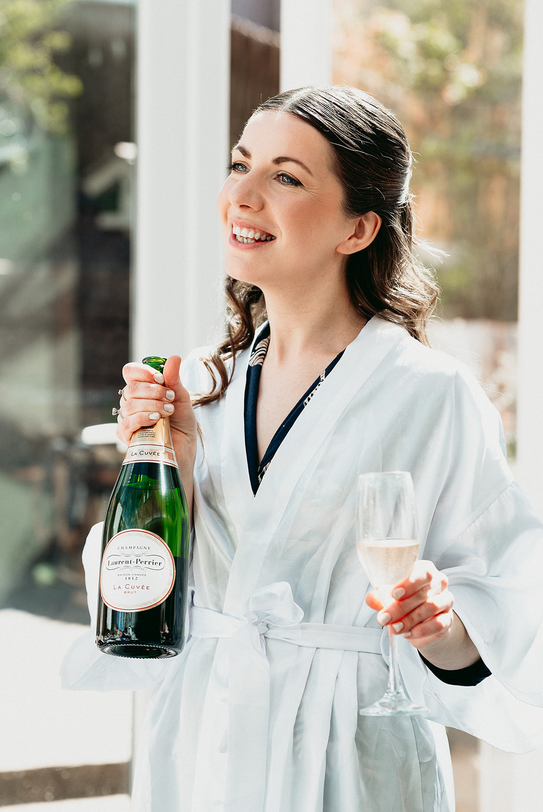 Bride raising a glass with her wedding party while getting ready at Fitzleroi Barn