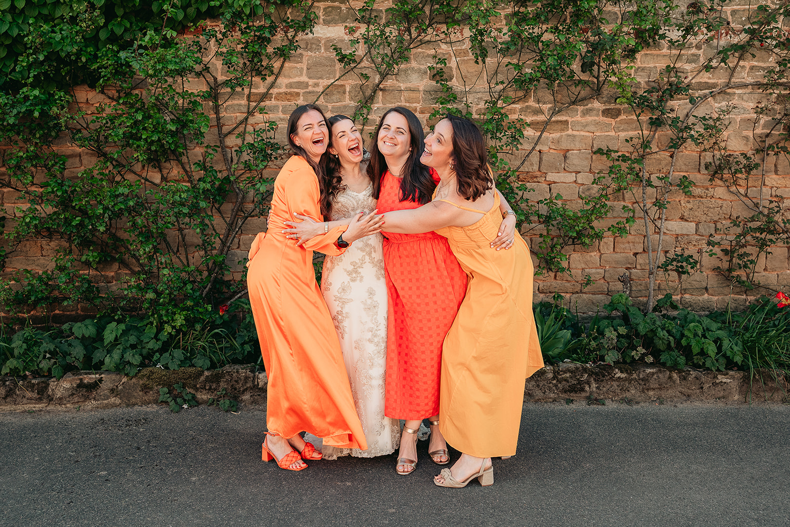 Jodie with her bridesmaids in vivid orange dresses at Fitzleroi Barn