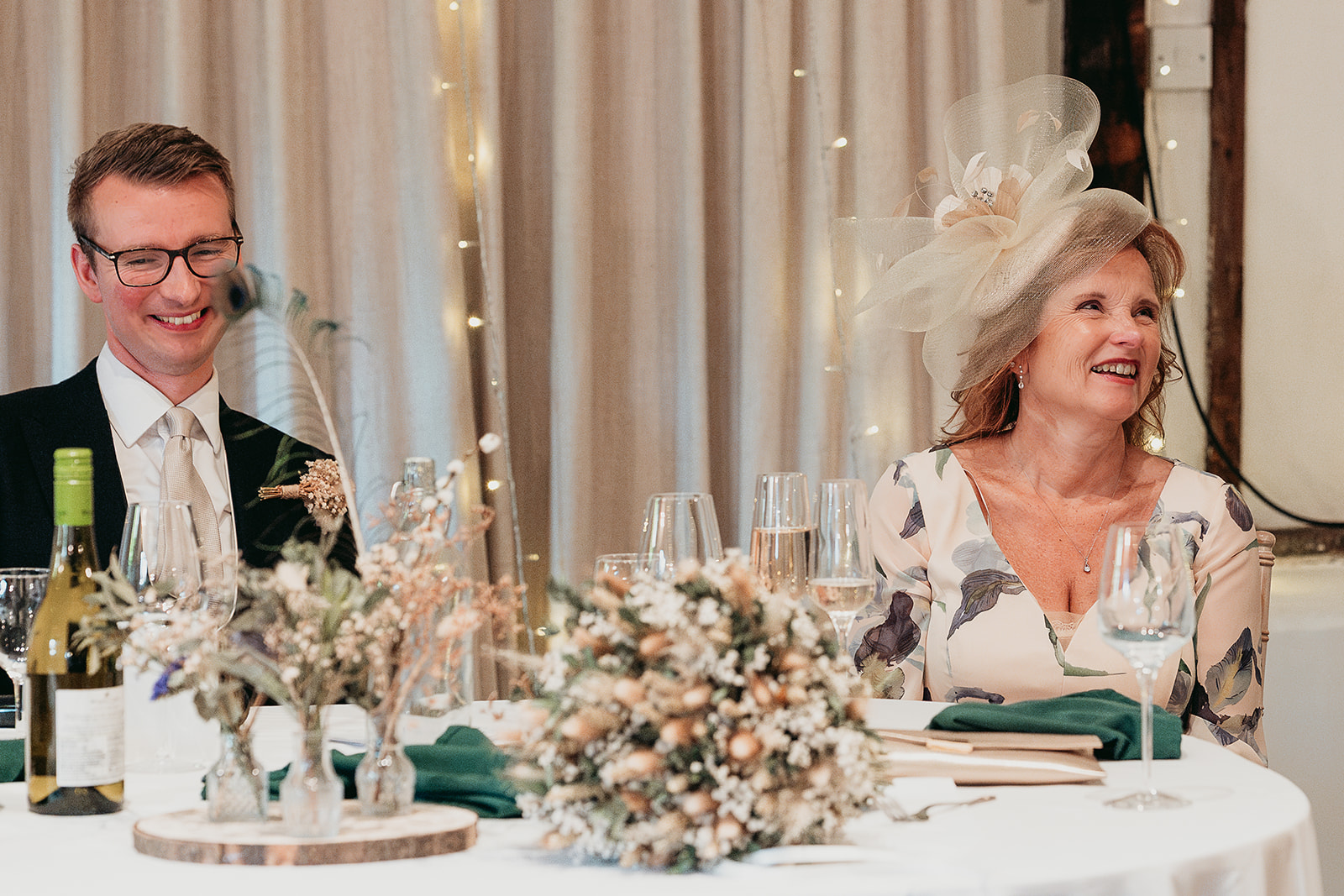 Jodie and Jordan laughing together at their wedding breakfast in the Main Barn