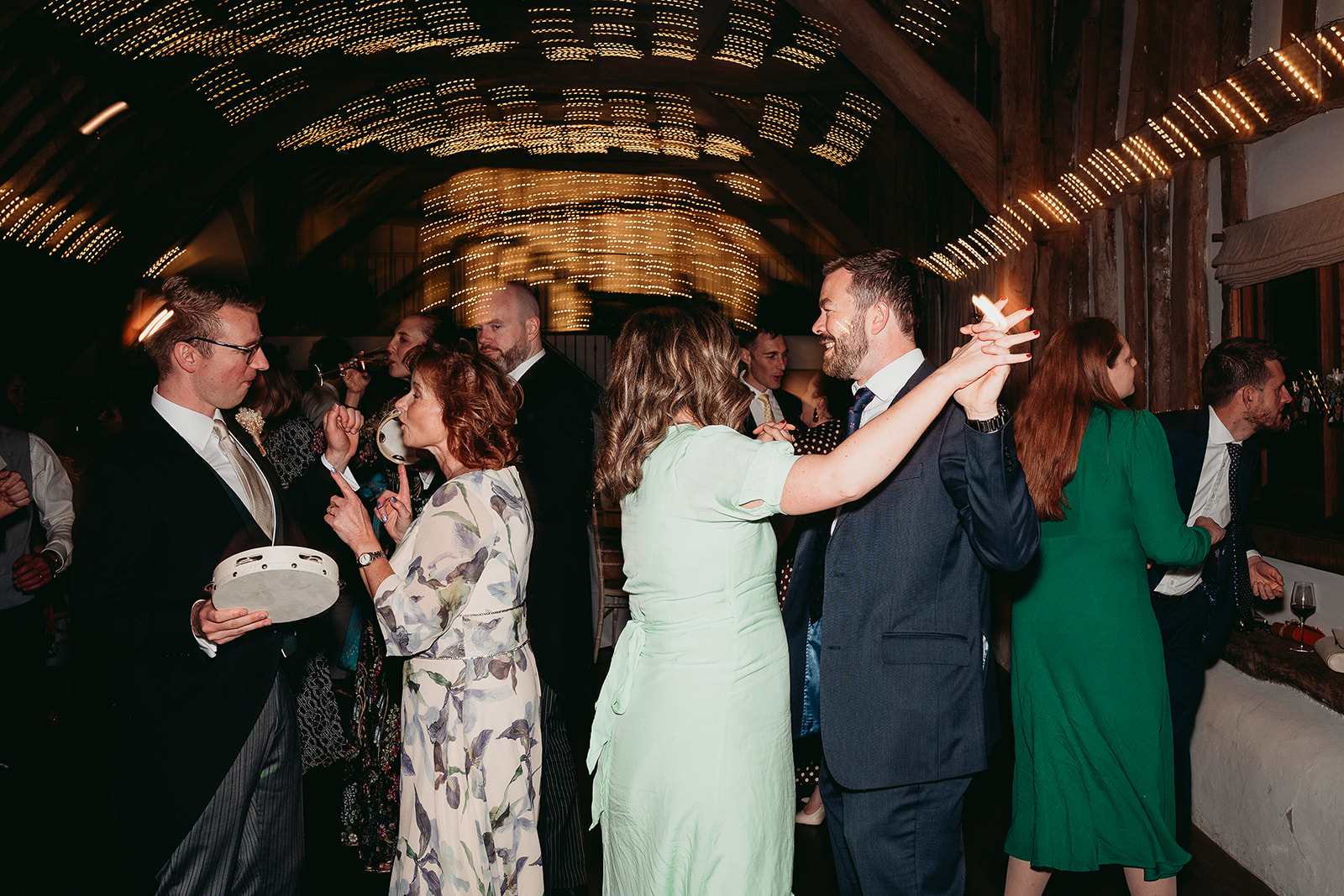 Wedding guests cheering together on the dance floor at Fitzleroi Barn