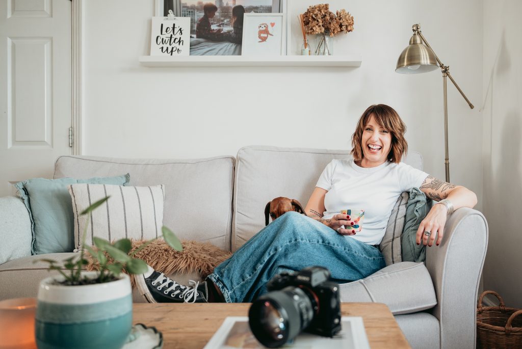 Photographer laughing with her camera during a relaxed personal branding session in Sussex