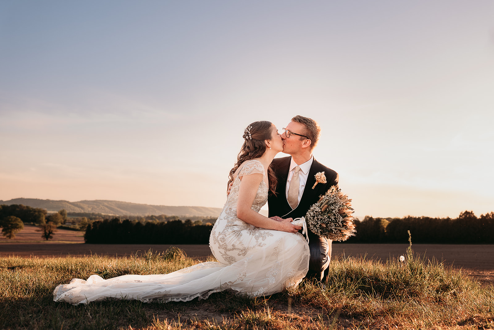 Jodie and Jordan overlooking the South Downs at golden hour from Fitzleroi Barn in West Sussex