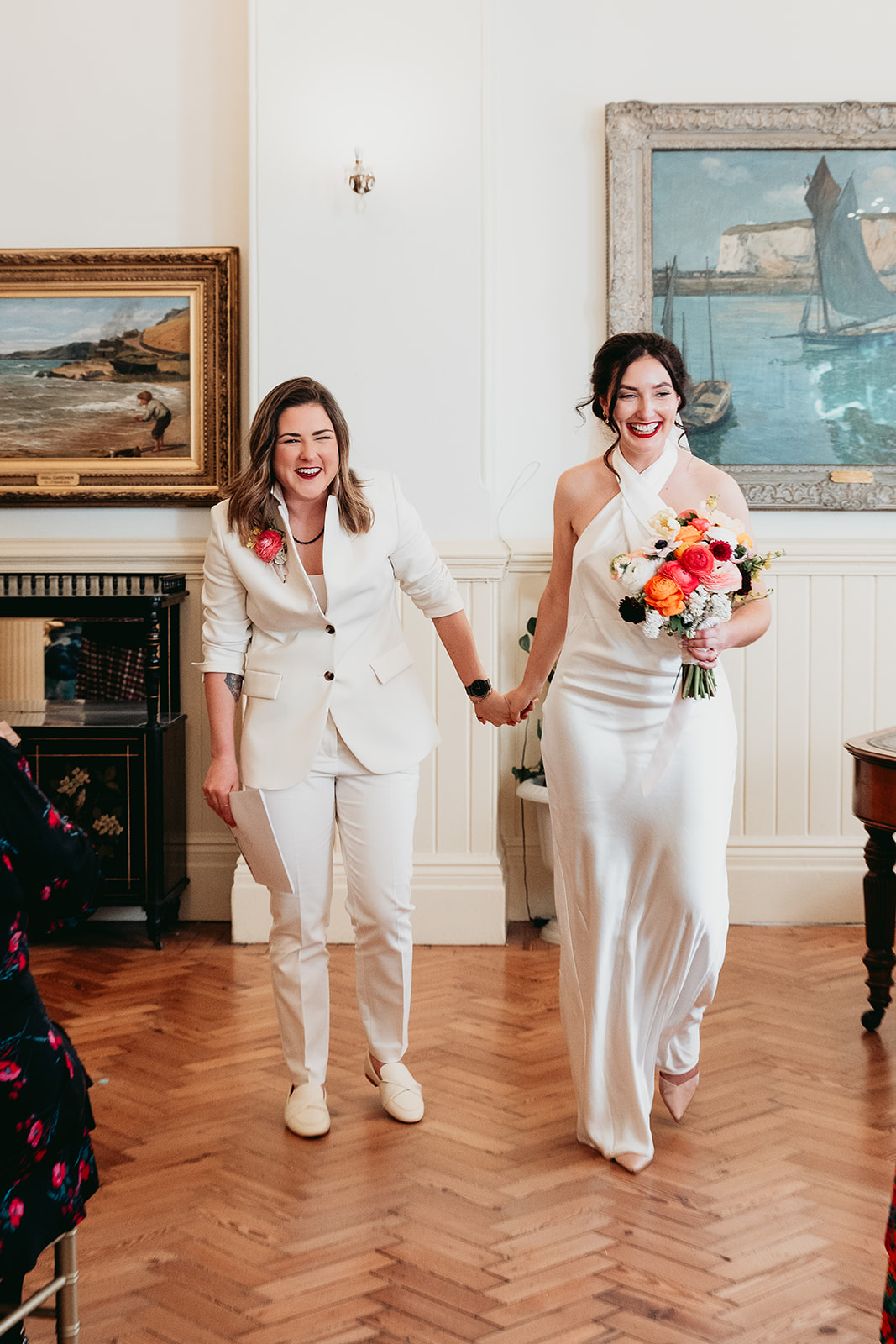 Two brides walking hand in hand after their ceremony at Brighton Town Hall