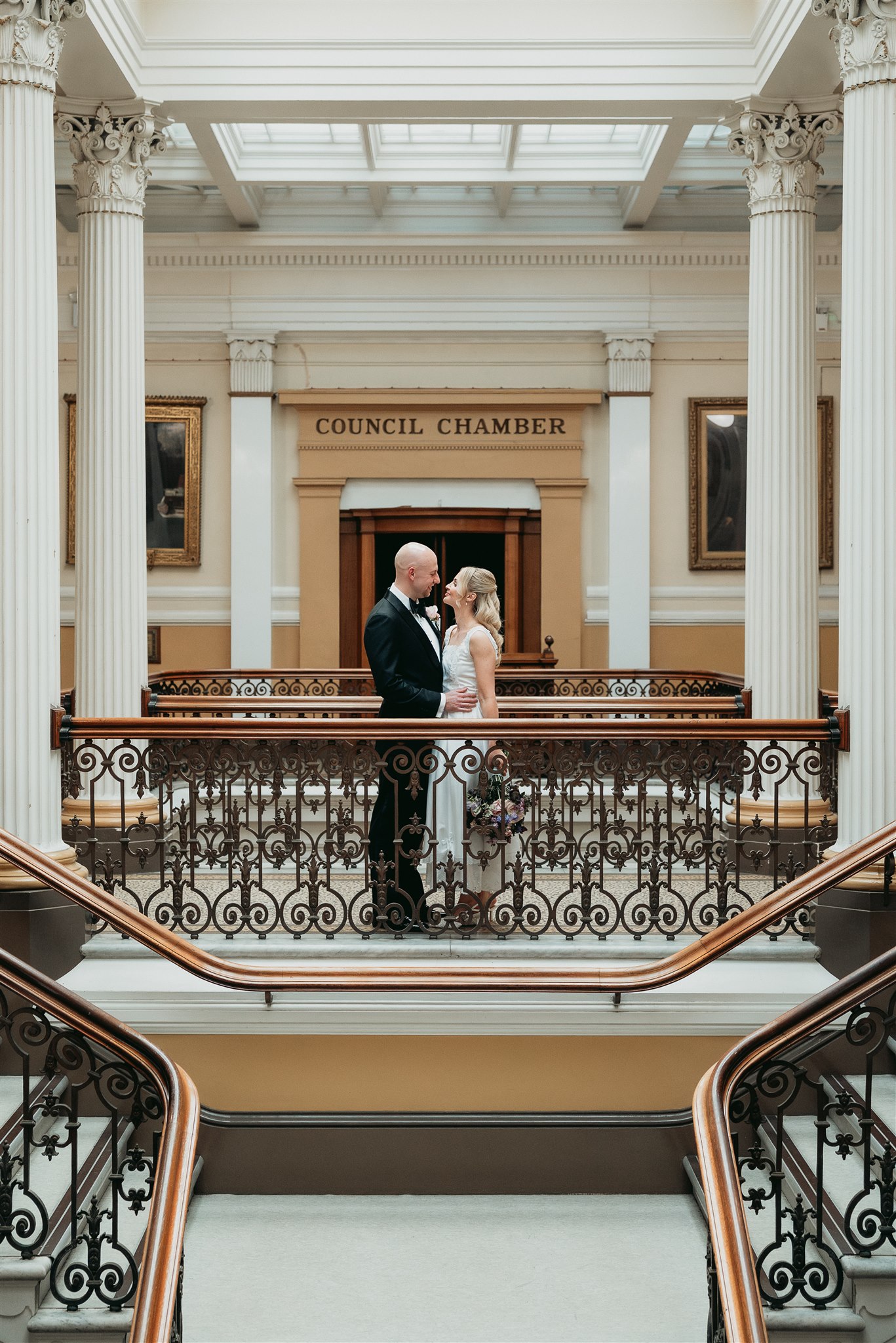 Bride and groom embracing on the Council Chamber staircase at Brighton Town Hall